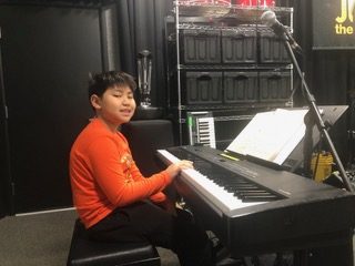 Young boy playing piano at Join The Band